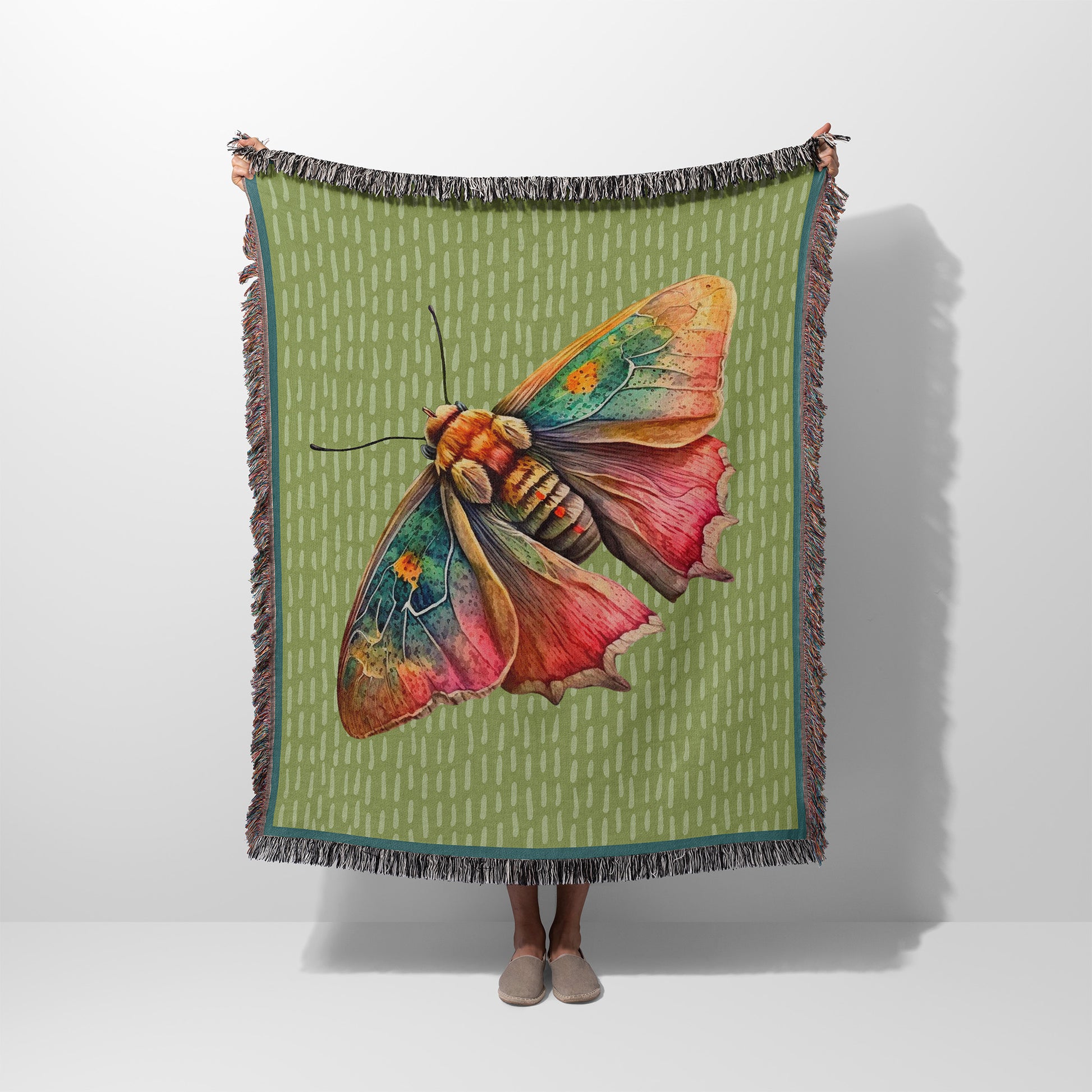 Woman holding up a woven blanket with a moth design