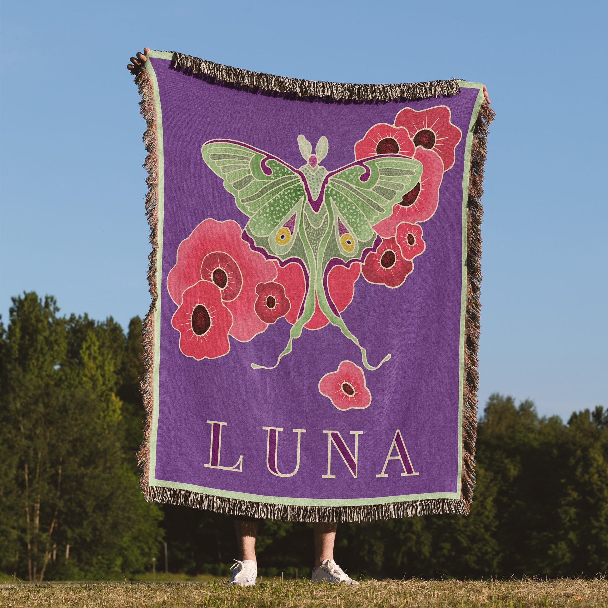 Woven blanket being held up by a woman